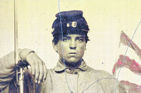 Unidentified soldier in Union uniform with bayoneted musket in front of painted background showing American flag and column pedestal