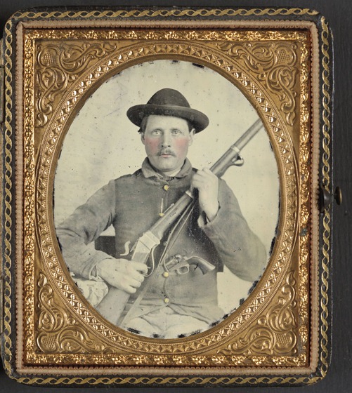 Unidentified soldier in Confederate uniform with Berdan's Sharps rifle and Colt 1862 Police Model pistol