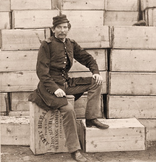 Union Captain J. W. Forsyth, the Provost Marshall, sitting on a crate of hardtack