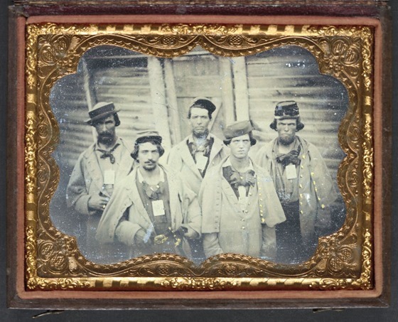 Five unidentified prisoners of war in Confederate uniforms in front of their barracks at Camp Douglas Prison, Chicago, Illinois