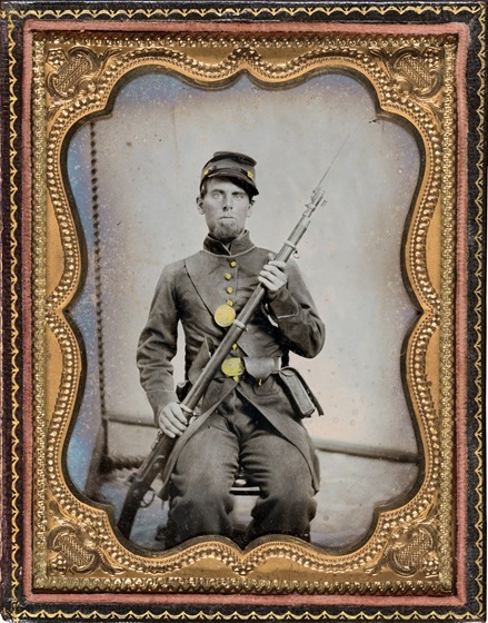 Unidentified soldier in Union uniform with bayoneted musket, cartridge box, and cap box in photo case