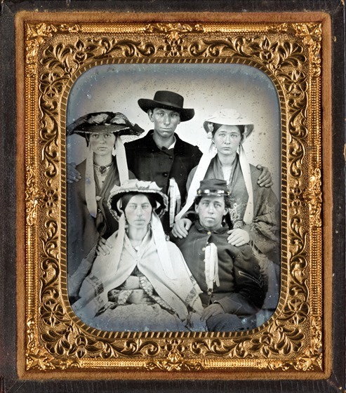 Unidentified soldier in Union uniform with three unidentified women in bonnets and one unidentified man in photo case