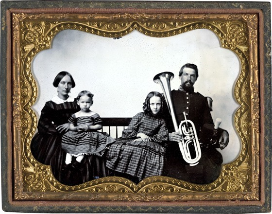 Unidentified soldier in Union uniform with wife and daughters holding saxhorn in photo case