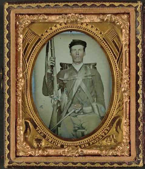Unidentified infantry soldier in Union uniform in full marching order with musket, canteen, cartridge box, cap box, and knapsack in case