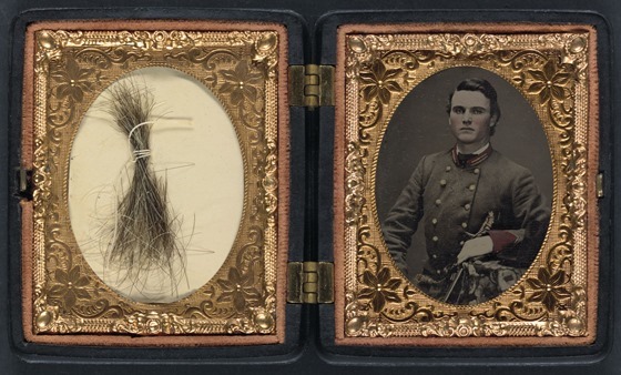 Unidentified soldier in Confederate artillery first lieutenant's uniform holding sword, with lock of hair in case