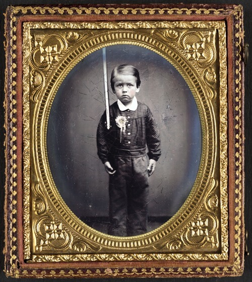 Unidentified young boy wearing secession badge and holding a rifle