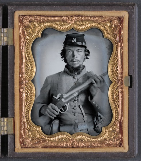 Unidentified soldier in uniform and Company K hat with musket; Confederate or Union -- in frame